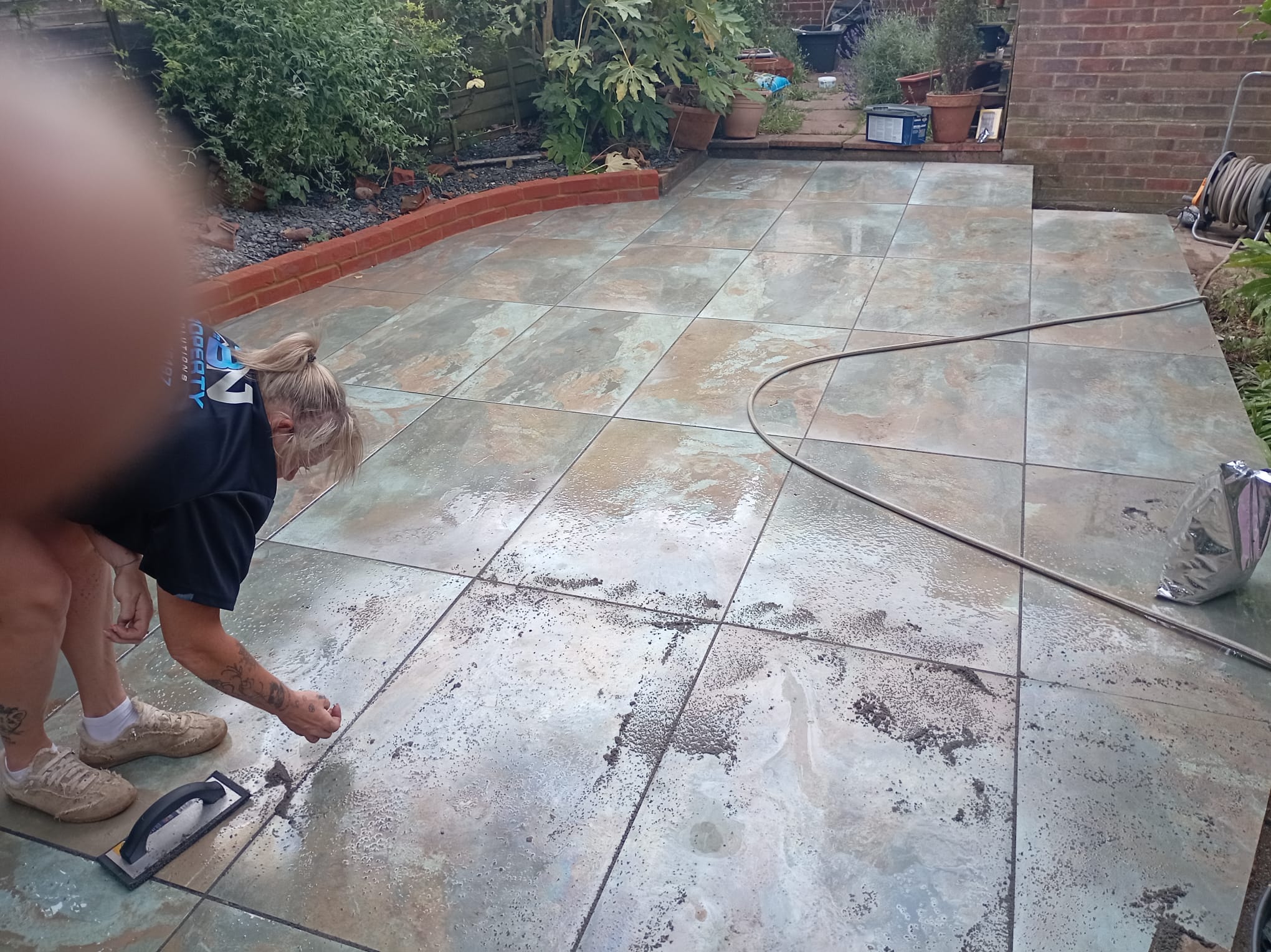 Riven sandstone patio being pointed and grouted