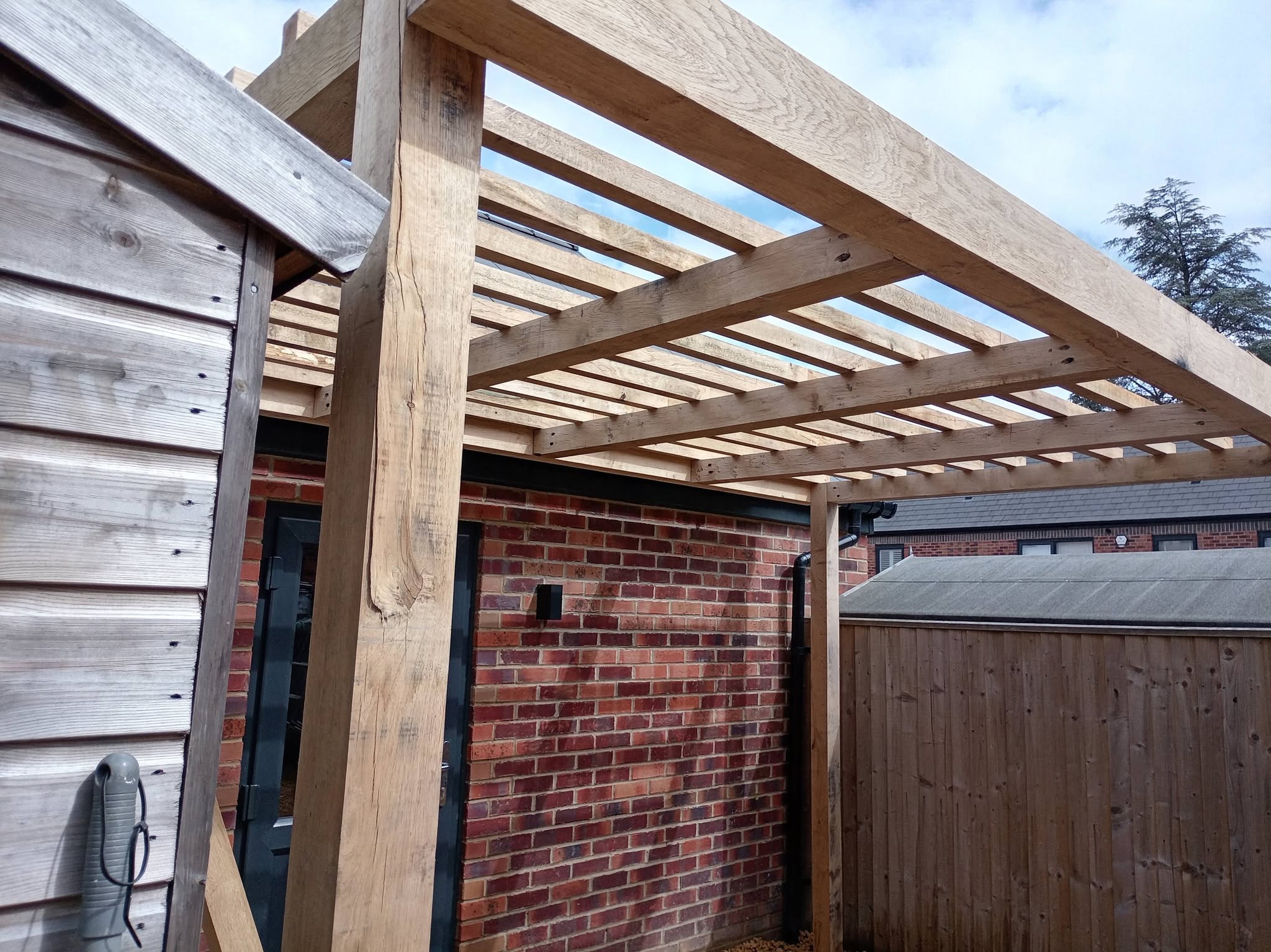 Oak-framed garden structure over a brick wall